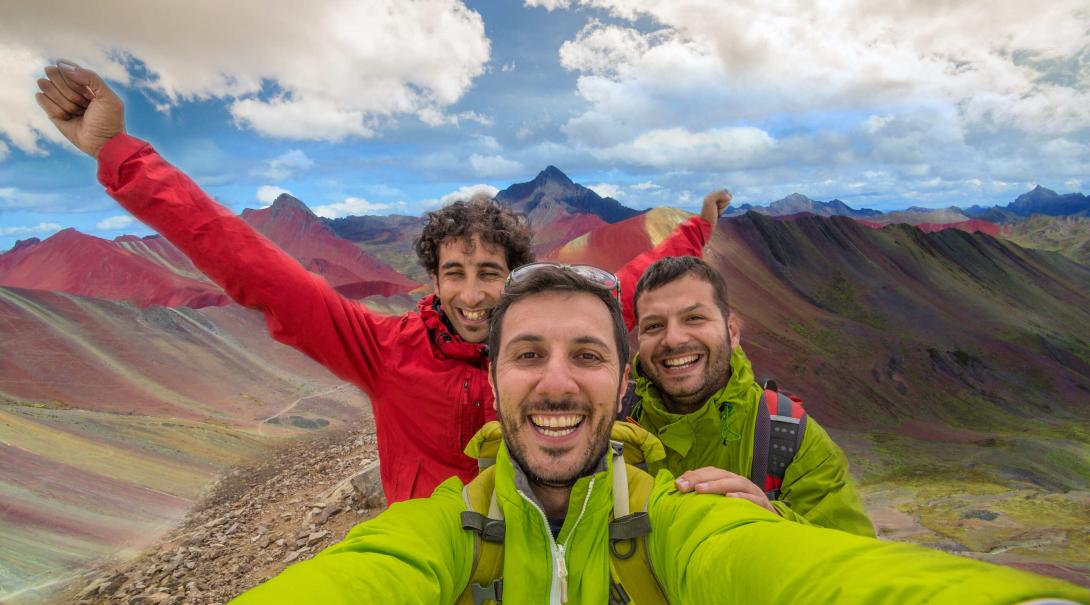Projects Abroad volunteers discover how travel changed them in 2020. Travellers take a selfie with the Rainbow Mountains of Peru in the background.